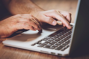 Hands typing on lap top